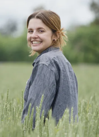 Maria Rottersman smiling in a green wheat field